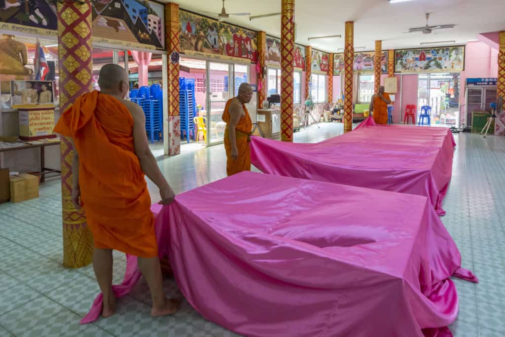 Mönche ziehen das Tuch über den Neugeborenen Buddhisten weg.