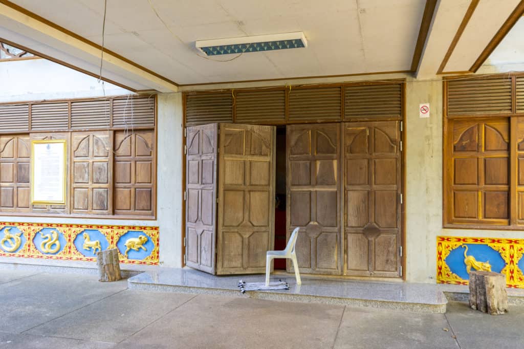 Eine kleinen Spalt offen stehende Tür im Tempelbereich
