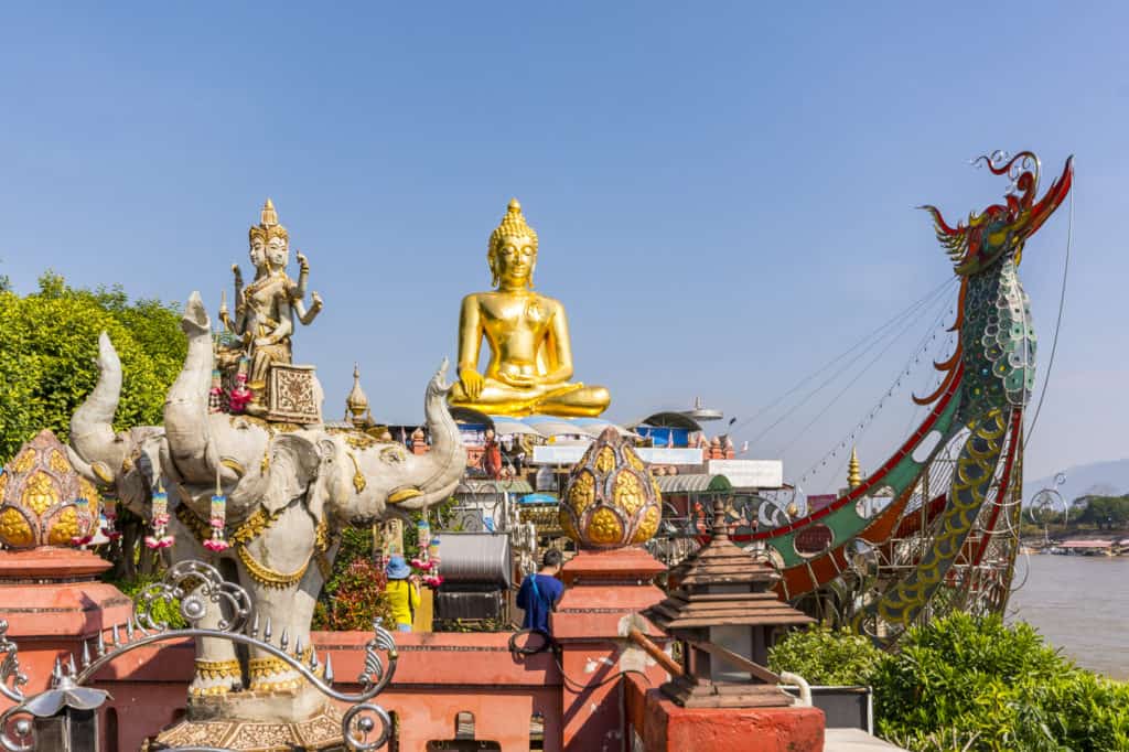 Farbenfroher Tempel mit goldenem Buddha am Mekong im Goldenen Dreieck