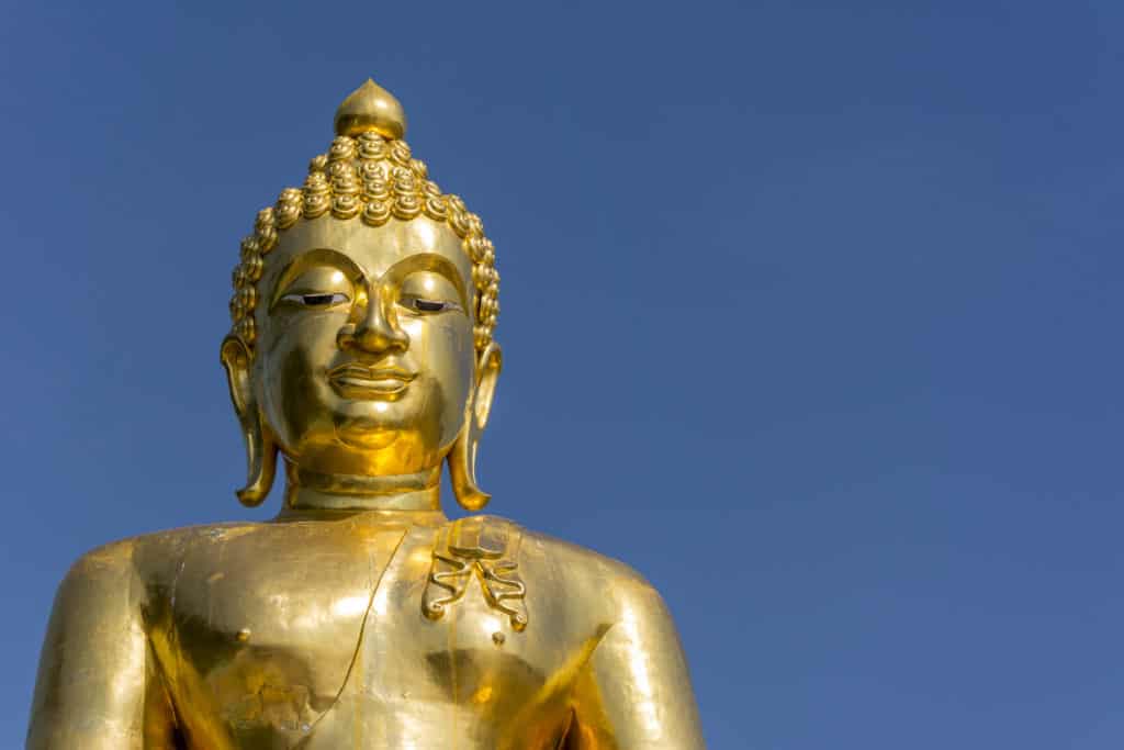 Die goldene Buddha Statue leuchtet im blauen Himmel am Goldenen Dreieck in Thailand