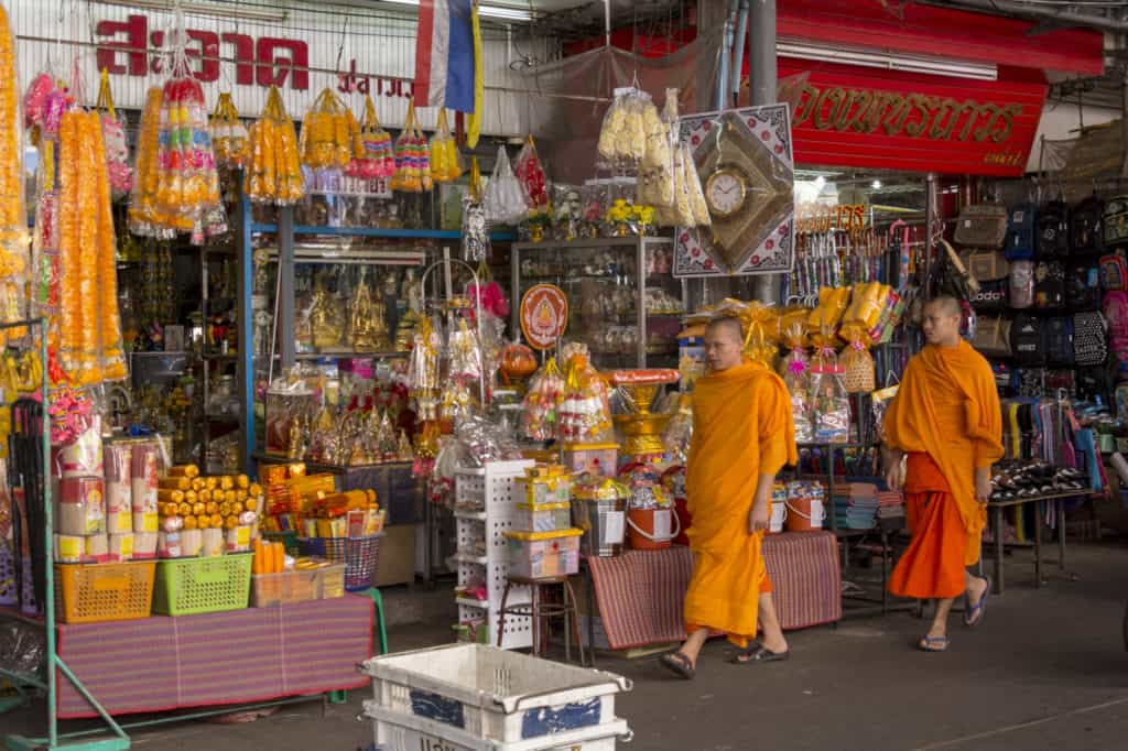 Mönche in Thailand vor einem Geschäft für religiöses Zubehör