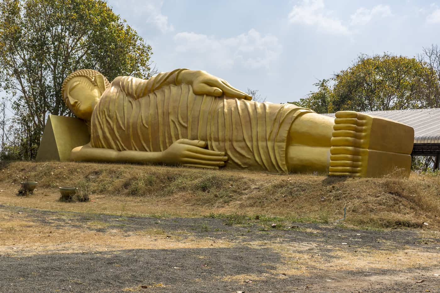 Thailand und der Beton hier ein liegender goldener Buddha mit faltigem Gewand aus Beton