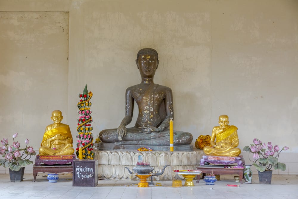 Buddha-Figur im Lotussitz mit überproportionalem Kopf