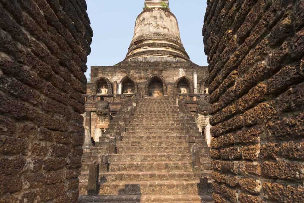 Durchblick beim Tor der zweiten Mauer auf die Treppen des Chedis im Wat Chang Lom in Si Satchanalai
