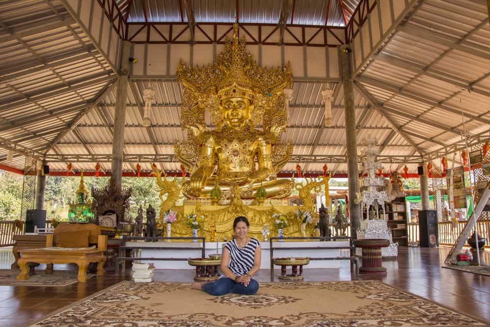 Sitzender Buddha im kleinen Bergtempel an der Bambus-Brücke