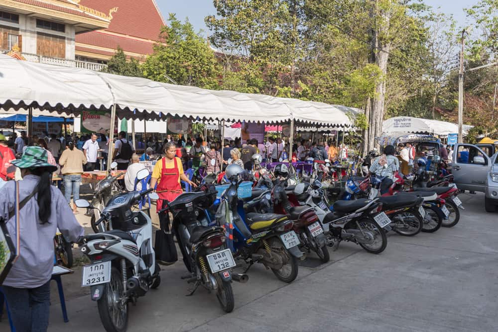 Dicht gedrängt Motorräder und Autos am Eingang des Wat Phet Wararam in Phetchabun