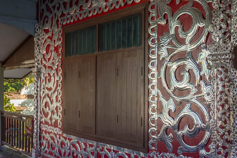 Die rote Farbe der Wände und der kühl wirkende Zinnbeschlag im Wat Chong Kham in Mae Hong Song