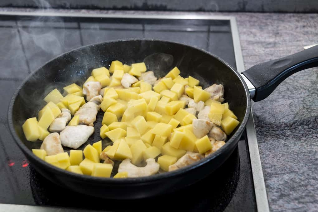 Hühnchen und Kartoffeln für das Curry in der Pfanne