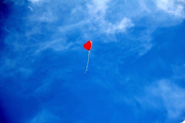 Luftballun in Herzform vor blauem Himmel