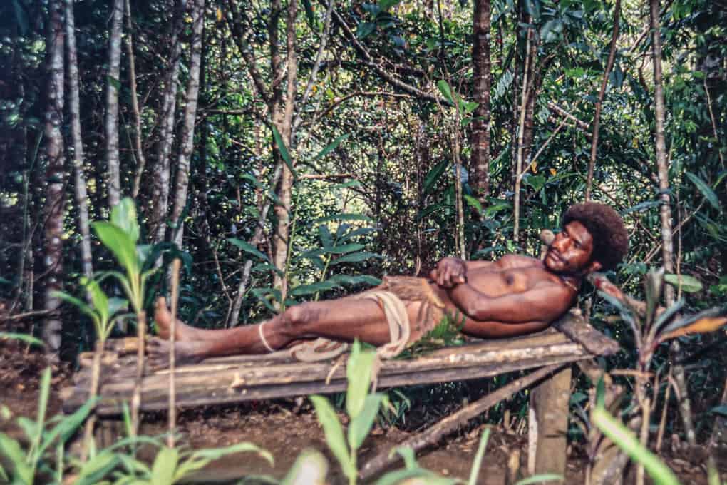 Mann demonstriert wie man in Papua-Neuguinea mit der Perücke schläft