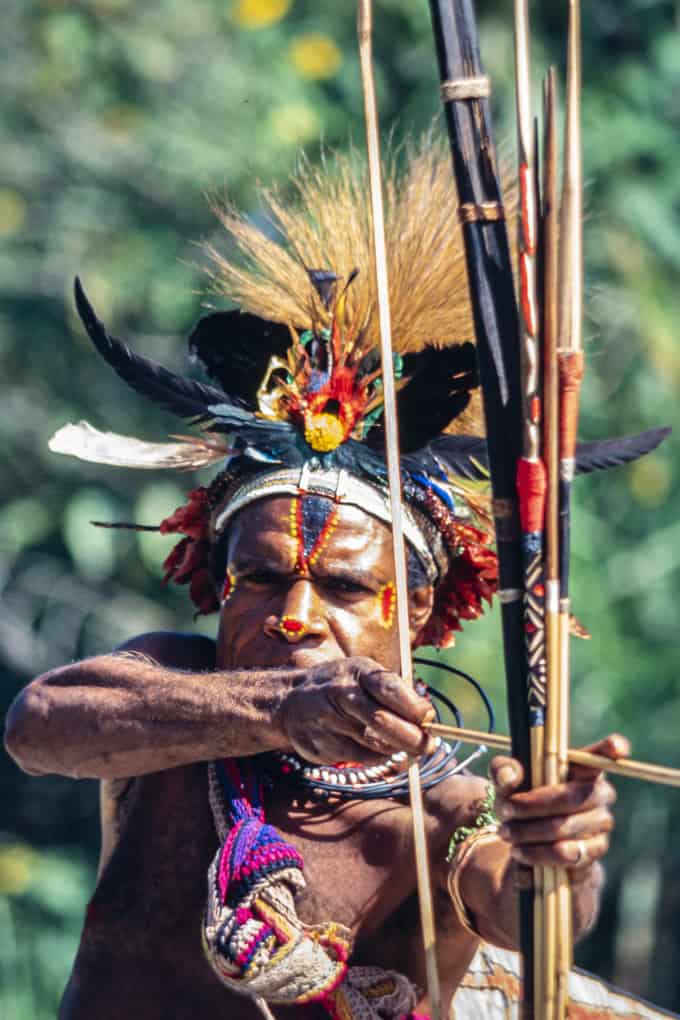 Bedrohlich zielt der Krieger mit Pfeil und Bogen auf uns in Papua Neuguinea