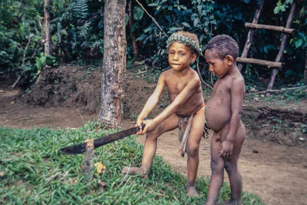 Kinder spielen mit einer Machete