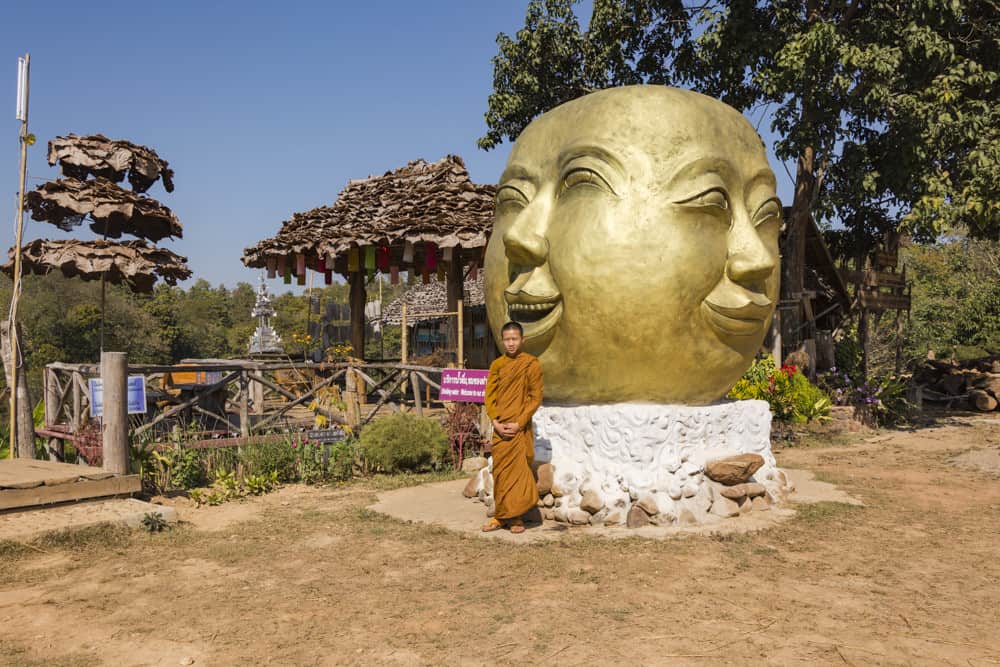 Junger Mönch steht vor einem besonderen Buddha-Kopf - Bambus-Brücke - Thailand - Sehenswürdigkeiten rund um Mae Hong Son