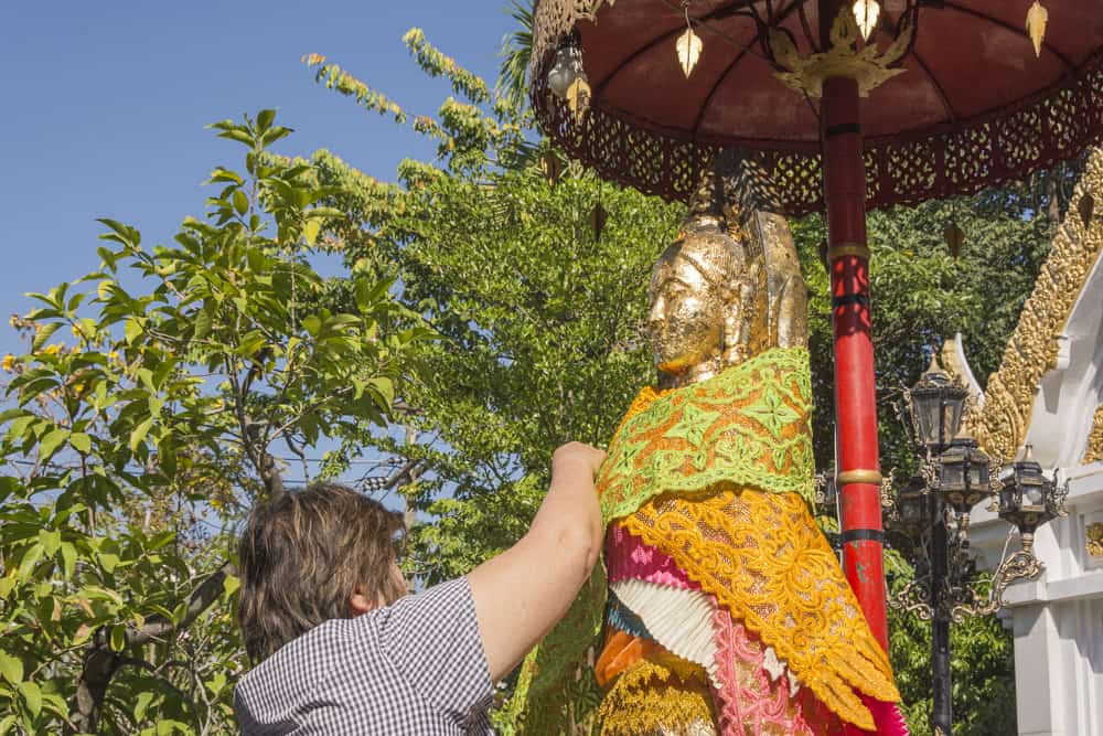 Aufkleben von Blattgold an den außen stehenden Figuren von Phra Mae Ya