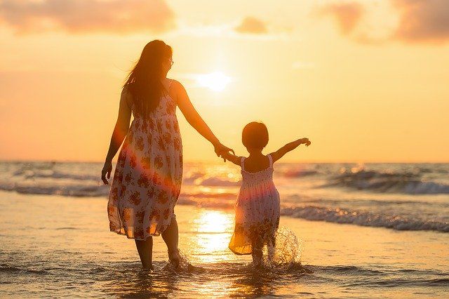 Thailänderin mit Kind im Sonnenuntergang in Thailand
