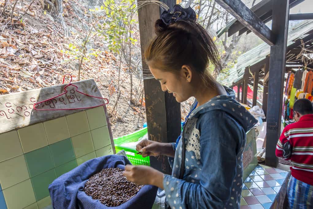 Junge Frau aus Myanmar die kleine Kerne zu Schmuckstücken auffädelte